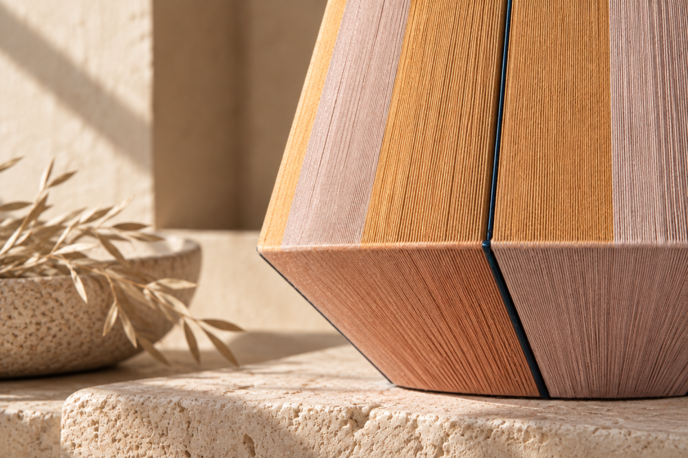 Close-up of the COB pendant lamp showing its woven thread texture, geometric form and warm earthy tones